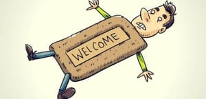 A human lying flat on the ground with a Welcome doormat as a body, signifying someone who lets themselves got walked on by others.